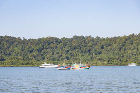 Fishing boats moored. Cruise ship at sea In the background is Mountain
