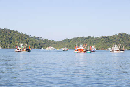 Fishing boats moored. Cruise ship at sea In the background is Mountainの写真素材