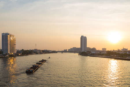 Bangkok evening and rivers General cargo ship Building high-rise buildings by the river During the evening,の写真素材
