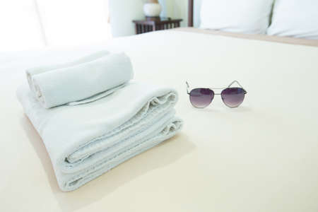 Towels placed on the bed. Sunglasses are placed side by side on site.の写真素材