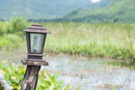 Lamp made of wood decorations on the path next to the river.の写真素材