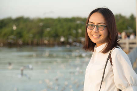 Asian woman wearing glasses smile happily on holidays.の写真素材