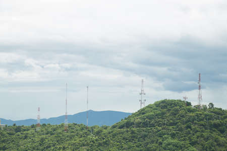 Signal towers of communication systems on the top of the hill and in the forest.の写真素材