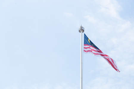 Malaysia flag in sky in midday with clear bright skyの写真素材