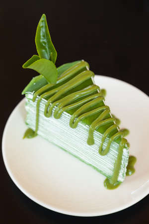 Green cake decorated by tea leaves and tea sweet sauceの写真素材