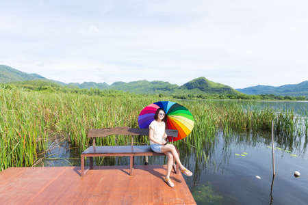 Woman sitting at the bench In an umbrella mobile in nature, the shady nature in the garden.の写真素材