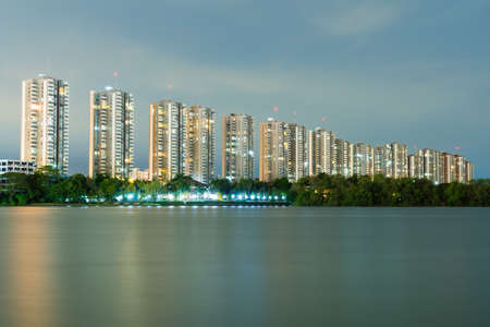 Condo luxury building in twilight near lake. Building condo and light in room evening.の写真素材