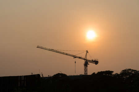 Construction cranes are on high buildings in Twilight.の写真素材