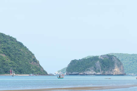 Small fishing boats in the sea. Behind the island is a tree covered.の写真素材