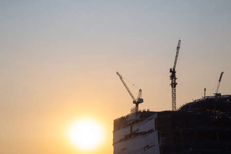crane on the building, the construction of a high-rise building in the eveningの写真素材