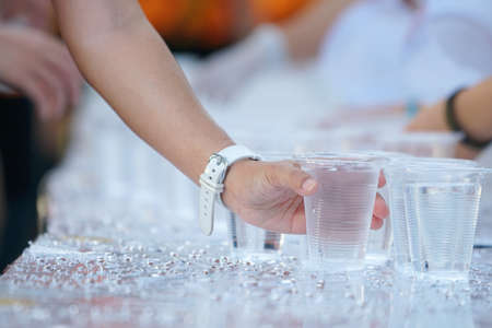 hand picking up the glass of the marathon runner