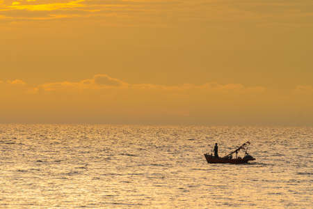 fishing boat in sunset. Sea and sunset cloud background in evening.の写真素材