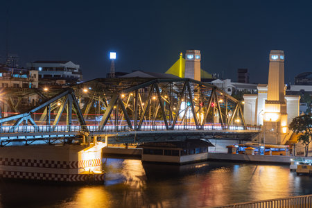 illuminated bridge at night reflects beautifully on water, showcasing vibrant cityscape. scene...
