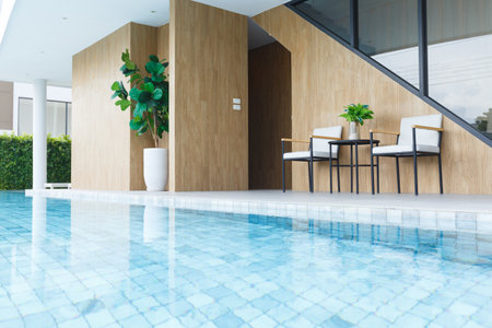 A Modern poolside seating area with plants and wooden accentsの写真素材