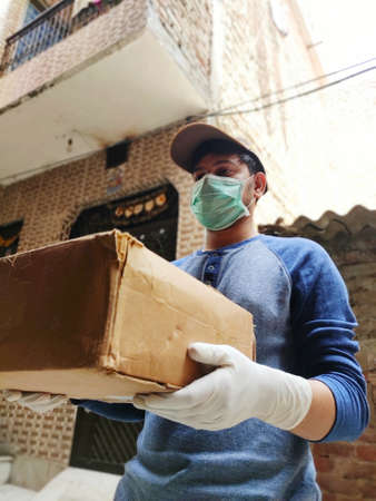 Courier Boy in Protective mask and medical gloves delivers Parcel Box, Delivery under quarantine,...