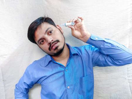 Ear drop use by man in Ear pain , White background selective focus.の写真素材