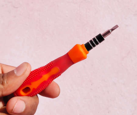 In hand small screwdrivers. metal screwdriver bits.Multi-bit repair tools kit set torx screwdrivers for gadgets isolated on a white backgroundの写真素材