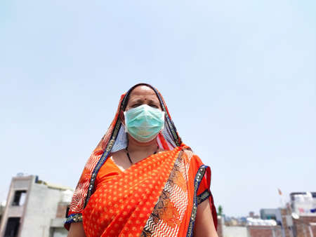 Indian woman in saari wearing face mask for corona virus protection.の写真素材