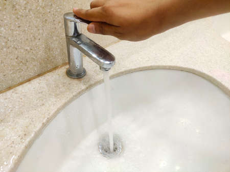 hand close water tap to stop water wastage. Selective focusの写真素材