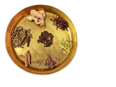 Ayurvedic herbs medicine ingredients on brass plate on white background top view.の写真素材