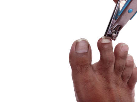 Feet finger nails cutting by cutter isolated on white background.