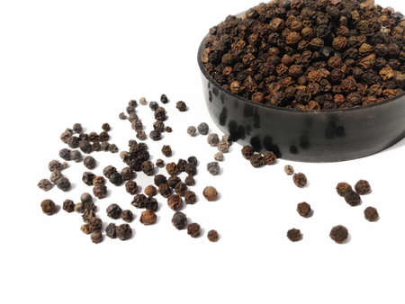 Dry Black peppercorns in bowl on white background sideview .の写真素材