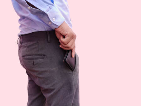 Close up man keeping his wallet money in the front pocket of pants. Background wallpaper white