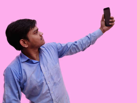 Man taking selfie on mobile isolated on pink backgroundの写真素材
