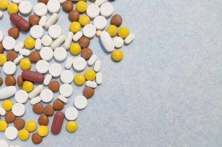 tablets and pills spread on blue background with copy space and Selective Focus