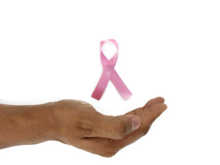 Pink ribbon breast cancer awareness symbol kept between hands as Support and care Concept