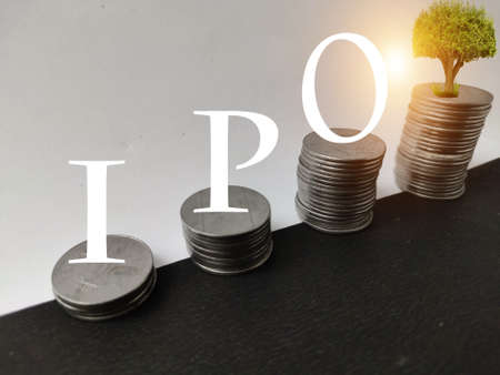 IPO initial public offering concept, stack of coins increasing on yellow background.の写真素材