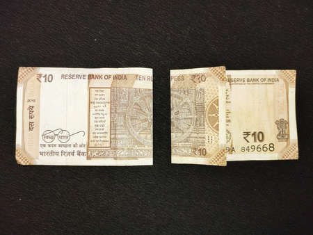 Ten rupees indian bank note currency folded kept on black background