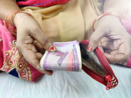 Notes keeping into wallet by woman hands closeup viewの写真素材