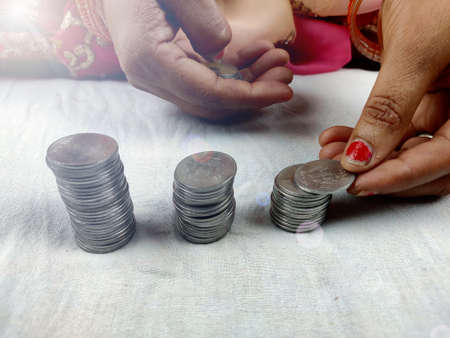 counting coins by stacking, woman hands holding coinの写真素材