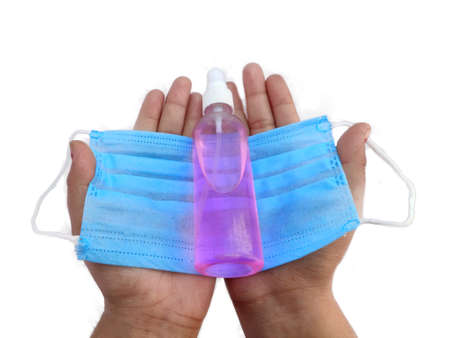 Respiratory medical face mask and hand sanitizer bottle on palm of Man or woman top view on white backgroundの写真素材