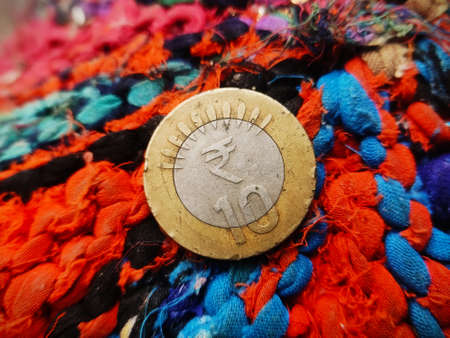 Indian Ten rupee coin placed on colourful Textured Backgroundの写真素材