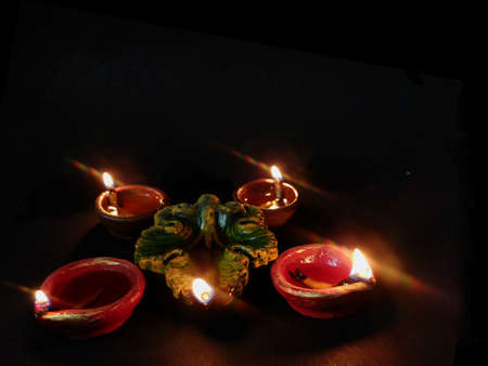 Happy Diwali - Clay Diya lamps lit during Dipavali, Hindu festival of lights celebration. Colorful...