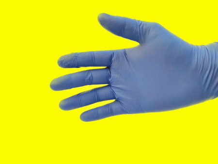 Human single Hand with gloves isolated on yellow background.