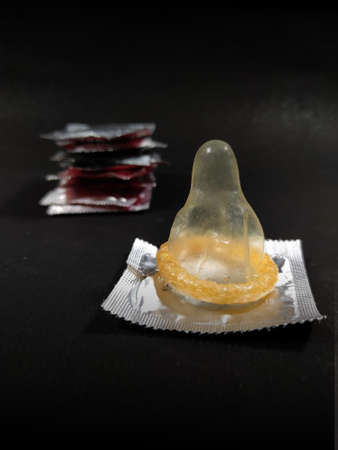 Male contraceptive Method Condom kept before Packets on black background with space for text.の写真素材
