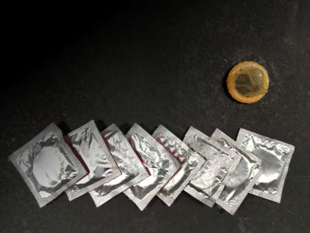 Condom a male contraception method packets on black background with space for textの写真素材