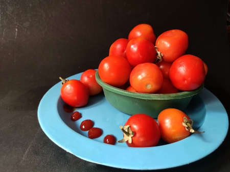 Tomatoes sauce made from fully ripen red Tomato kept in plate on black backgroundの写真素材