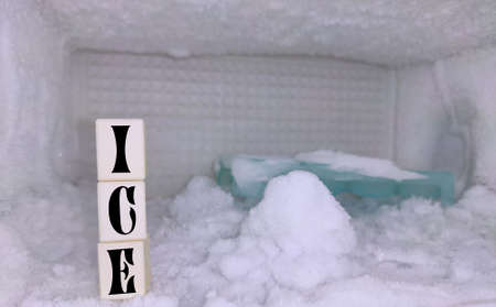 Ice background of refrigerator freezer with ice cube tray , white background with blocks written ICE...