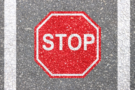 Sign board of STOP symbol red colour painted on road in the laneの写真素材