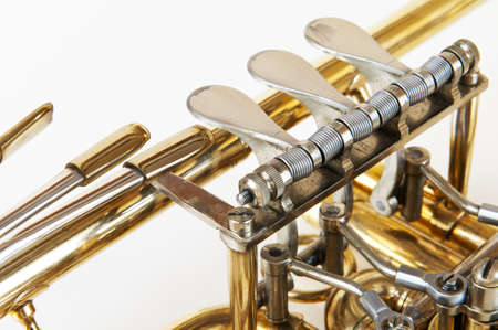 silver golden trumpet valves in detail view with white backgroundの写真素材