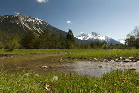 nice nature landscape with water, flowers, grass, meadows and tyrol mountainsの写真素材