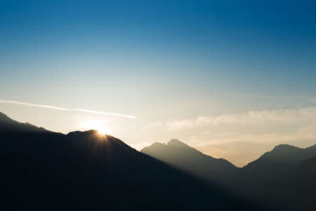 light beam on edge of mountain at sunrise and blue skyの写真素材