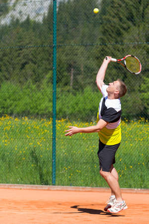 male tennis player hits the service ballの写真素材