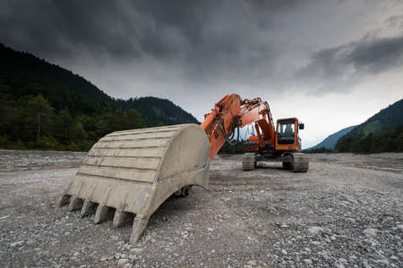 perspective of digger power shovel in red on gravelの写真素材