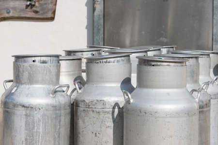 several empty silver cow milk cans with capの写真素材