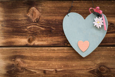 wooden grey heart with edelweiss on sun burned wood planksの写真素材